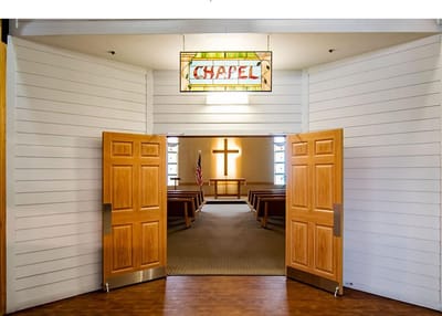 Interior view of a chapel with open doors