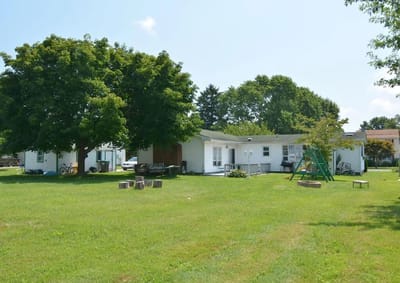 Outdoor space with green grass and trees near the facility