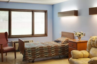 Private resident room with a bed and chair