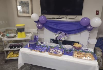 A decorated table with purple-themed snacks and drinks