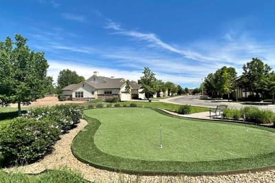 Outdoor putting green with landscaping and blue sky