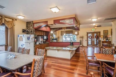 Bright dining room with wooden tables and kitchen area