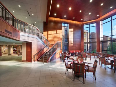 Bright common area with dining tables and staircase