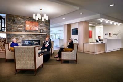 Residents socializing in a common area with a fireplace