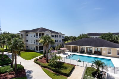 Glenbrooke at Palm Bay, assisted living in Palm Bay, FL — Senior living facility with palm trees and swimming pool