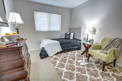 Cozy interior of a resident's room with a bed and chair