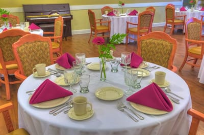 Dining room set up for a meal with elegant table settings