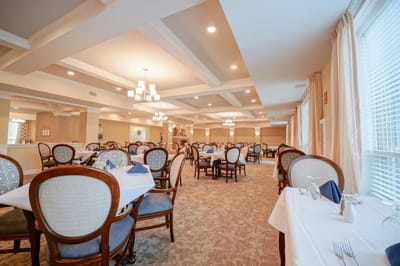 Bright dining room with well-set tables and chairs.