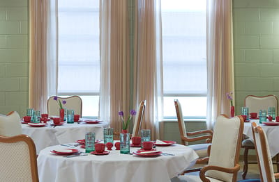 Dining area with elegantly set tables and flowers