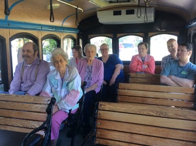 Residents enjoying a ride on a facility vehicle