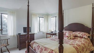 Brightly lit private resident room with a bed and windows