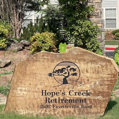 Stone sign with facility name in garden