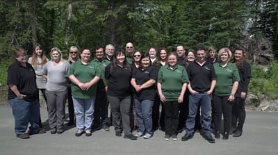 Group photo of facility staff outside among greenery