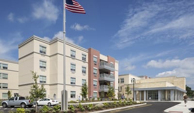 Exterior view of a senior living facility with residents