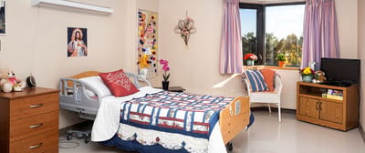 Cozy resident room with bed, dresser, and window view