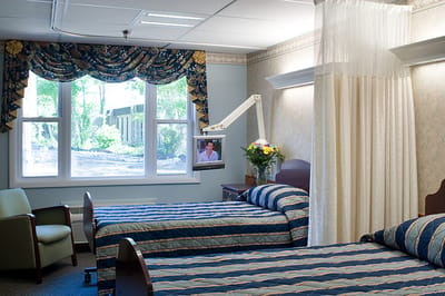 Private resident room with two beds and a TV