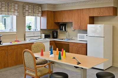 A bright kitchen area with tables and appliances
