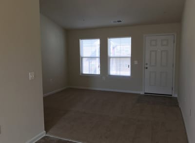 Empty interior room with carpet and windows