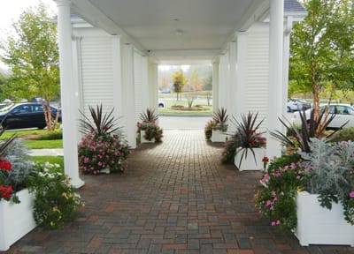 Pathway entrance with flower pots at a senior living facility