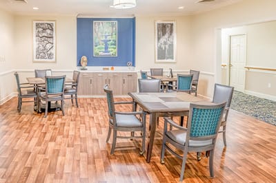 Bright common area with tables and chairs for residents