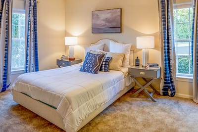 Bright, cozy resident room with a bed and artwork