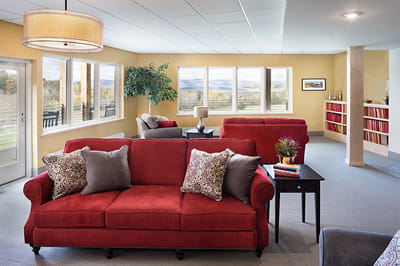 Bright common area with red sofas and scenic views