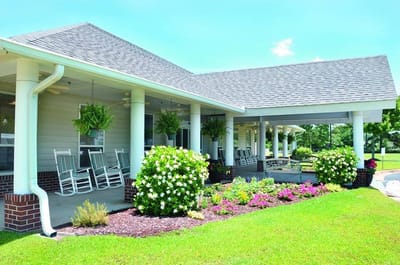 Exterior view of North River Village with rocking chairs and flowers