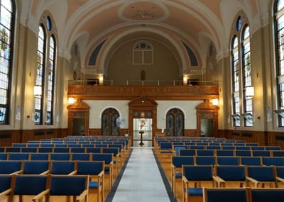 Interior view of a spacious chapel with wooden pews