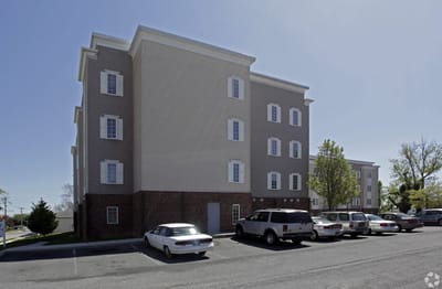 Owens Manor, independent living in Dover, DE — Senior living facility exterior with parking lot and trees