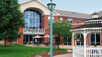 Exterior view of a senior living facility with outdoor seating