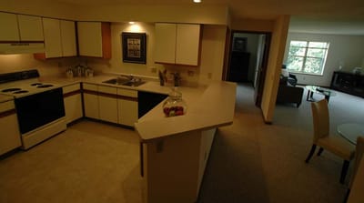 Bright kitchen area with seating and living room visible