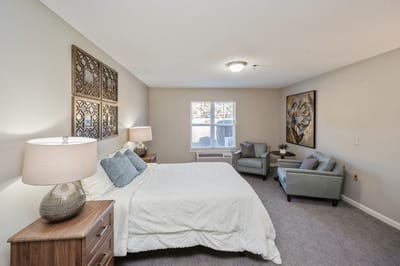 Cozy interior of a resident room with a bed and seating area