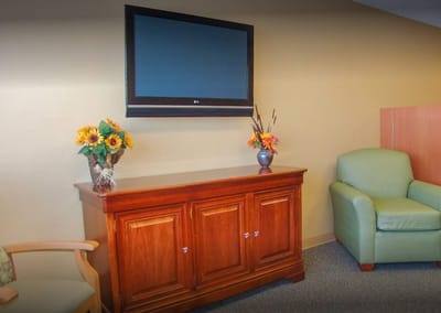 Brightly decorated common area with a TV and furniture