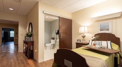 A cozy resident room with an open bathroom