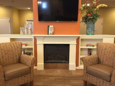 Interior view of a cozy common area with chairs and a television