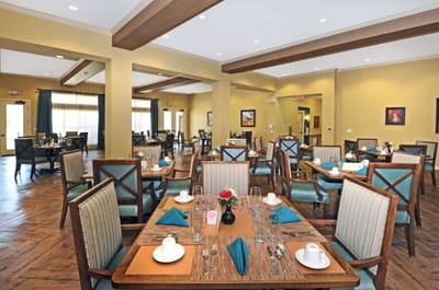 Dining room setup with tables and chairs ready for residents