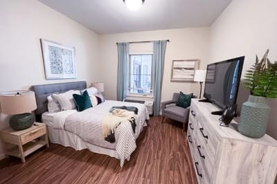 Cozy interior of a resident room with bed and furniture
