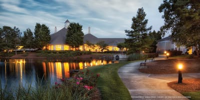 Exterior view of a senior living facility by a pond