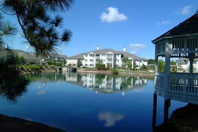 Scenic view of a pond with surrounding senior living buildings