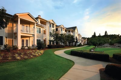 Exterior view of a senior living building with gardens