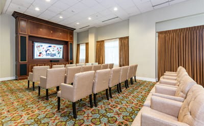Bright common area with seating and large screen