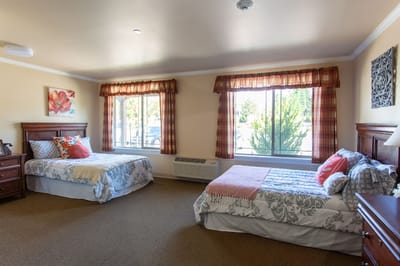 A cozy double room with two beds and bright windows