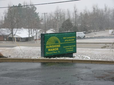 Signage for Sunshine Manor on a snowy day