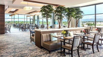 Elegant dining room with large windows and greenery