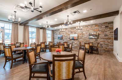 Bright dining room with wooden tables and stone wall