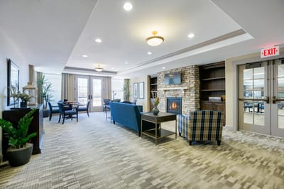 Common area with seating and fireplace in a senior living facility