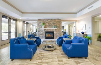 Bright interior common area with blue seating and fireplace