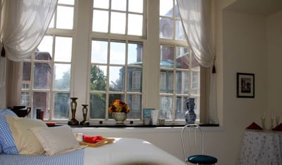 A cozy resident room with large windows and décor