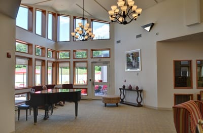 Bright common area with large windows and piano
