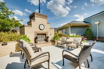 Outdoor seating area with clock and greenery